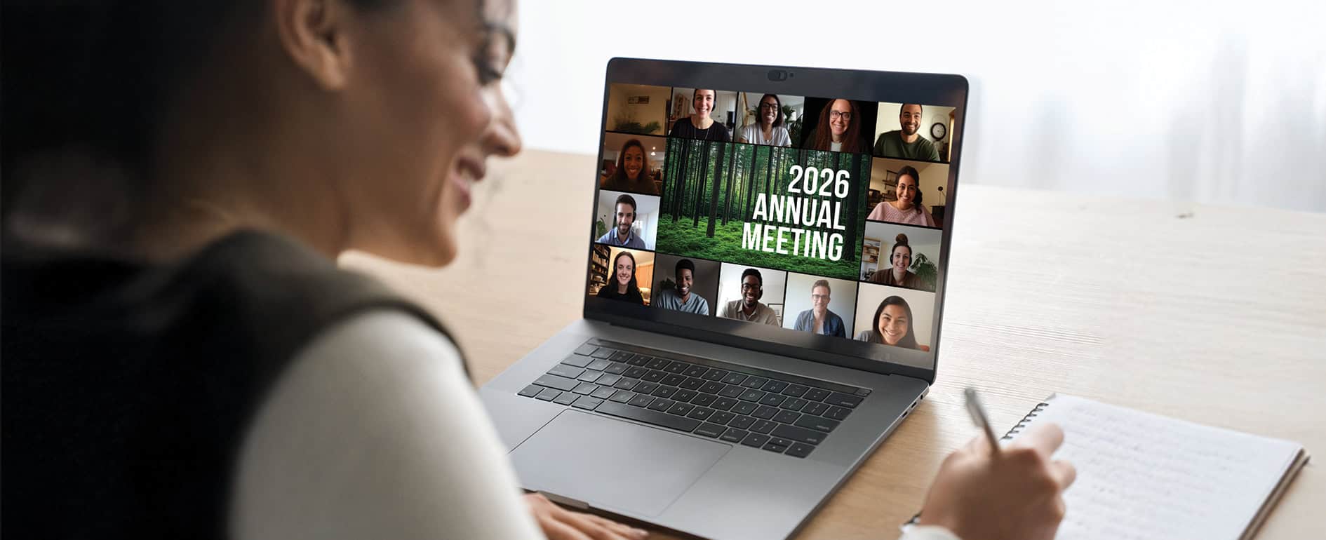 Woman at a desk attending a virtual meeting on a laptop