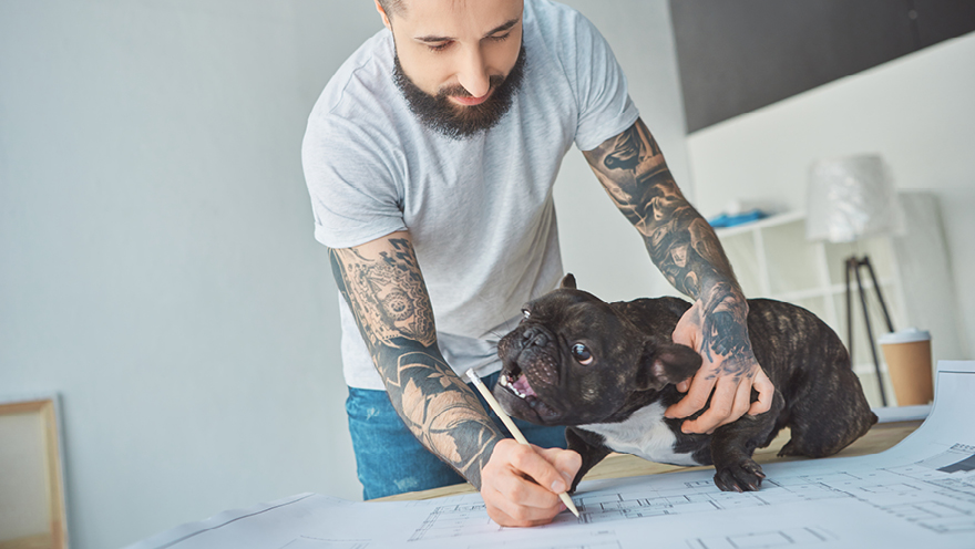 Man with dog and blueprints.