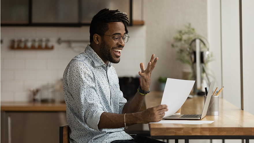 Happy man looking at paperwork at home.