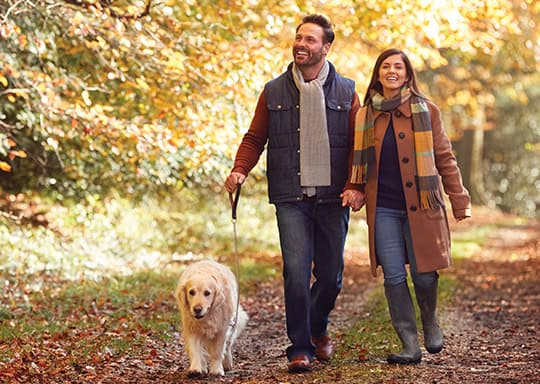 Couple walking on a trail with their dog.