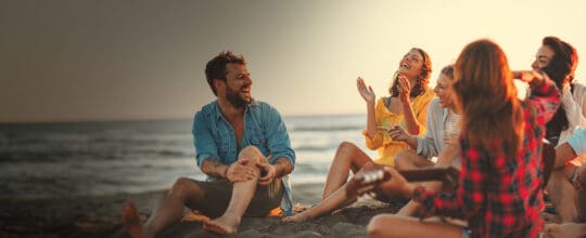 Friends enjoying a beach bonfire.