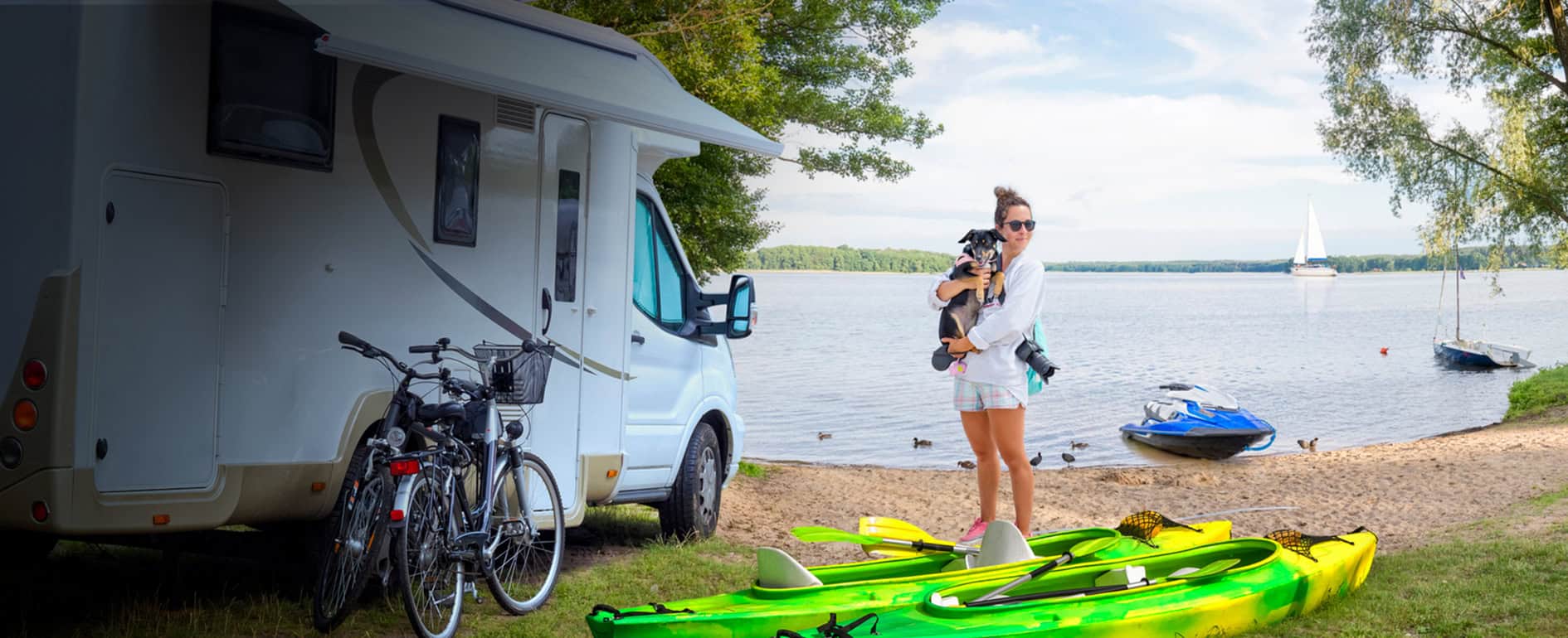 Woman and dog next to an RV on the lakeshore.