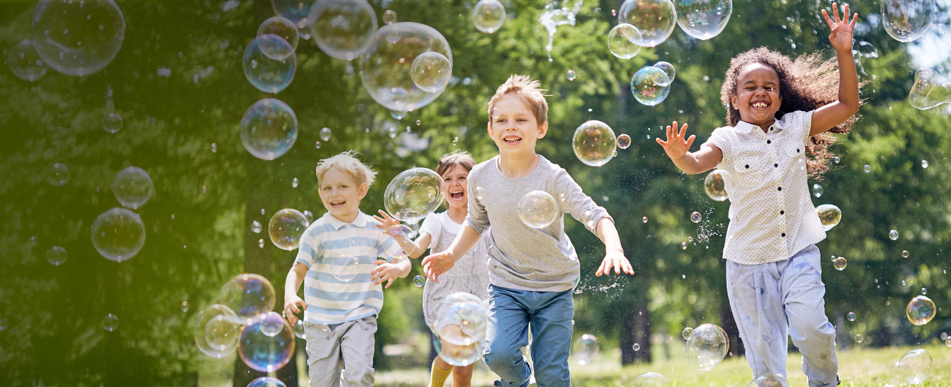 children running outside blowing bubbles