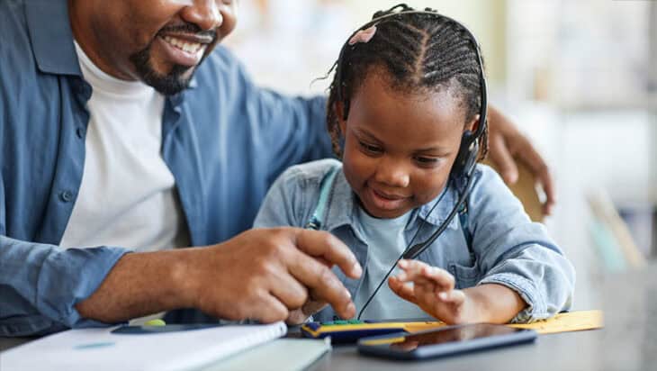 father and child playing with toy calculator learning to count together