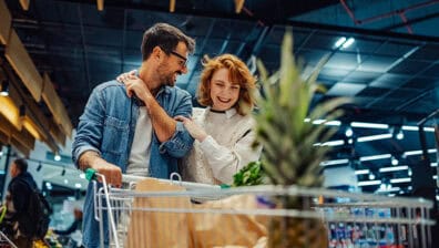Cheerful couple pushing a shopping cart