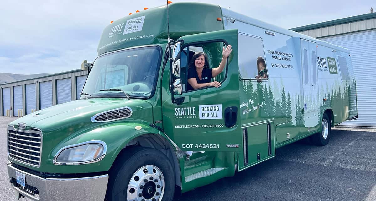 Woman waving from the cab of the mobile branch truck