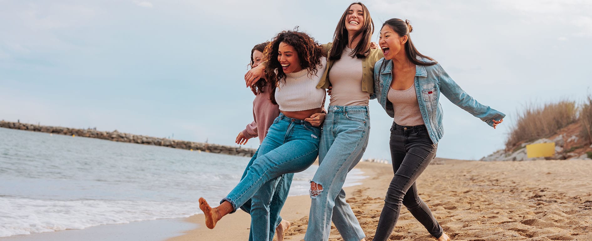 Four young women walking on the beach